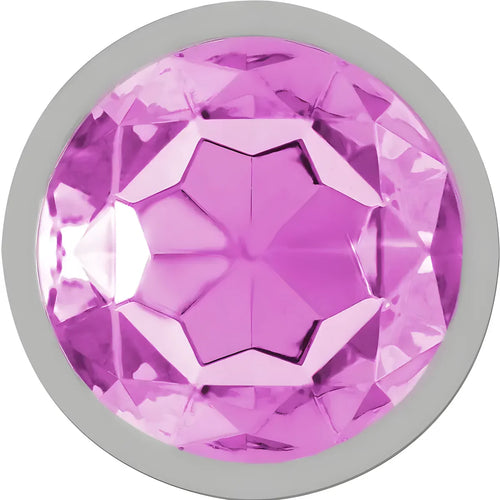 Gros plan sur le cristal rose à facettes serti sur la base du plug anal metal Intense, finition bijou brillante mise en valeur sur fond clair.