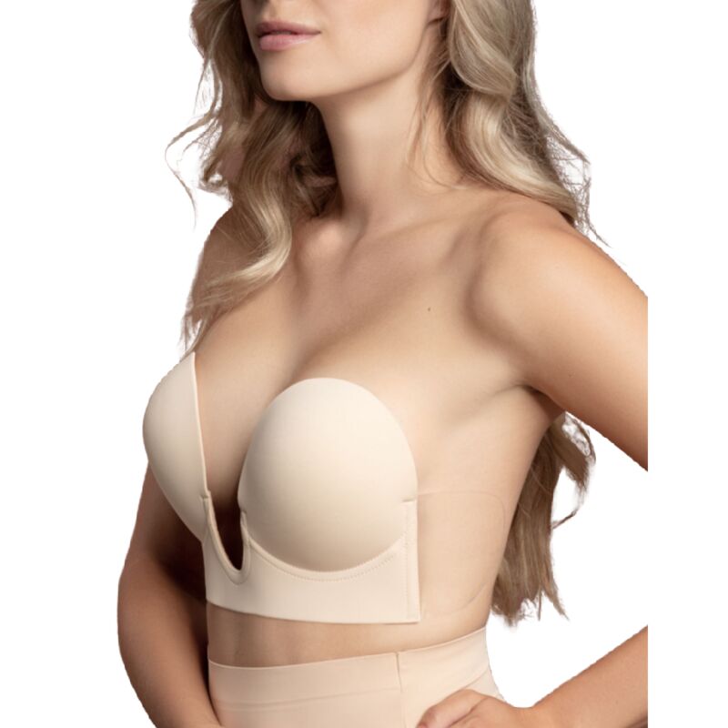 Modele de trois quarts portant le soutien-gorge adhesif beige sans bretelles a decollete en V, epaules et buste degages, rendu invisible discret.