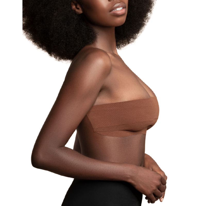 Body tape adhesif Bye Bra coloris caramel pose en bandeau de profil pour soutenir les seins, ruban extensible resistant a la sueur, demonstration laterale sur modele a la peau foncee