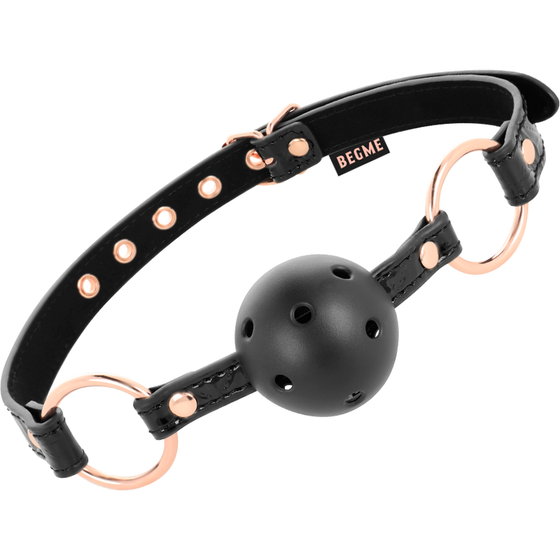 Bâillon boule Begme avec sphère noire perforée et serre-tête cuir vegan, anneaux or rose, accessoire BDSM réglable à trous de respiration.