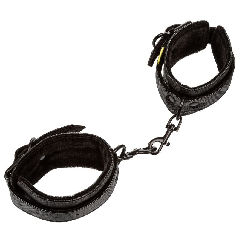 Manchettes de retenue Boundless en cuir synthétique noir doublé velours reliées par une chaîne métal, fermoirs pivotants pour poignets, circonférence max 30,5 cm.