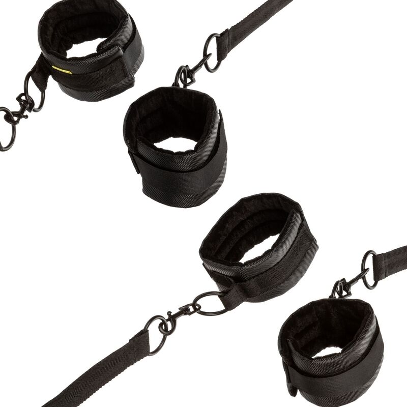 Quatre menottes Boundless en cuir vegan doublé fourrure noire reliées par des sangles à mousquetons pivotants, kit de contention de lit réglable et démontable.