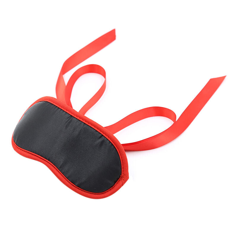Masque occultant satin noir et rouge presente avec ses longs rubans de soie ecartes, accessoire textile de privation de la vue pour des jeux sensoriels en couple.