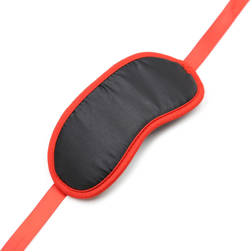 Bandeau pour les yeux en satin noir borde de rouge presente sangle tendue, ruban de soie deploye, accessoire fetichiste leger pour couper la vue et eveiller les sens.