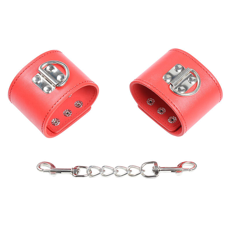 Paire de manchettes en simili cuir rouge a fermoir metallique D-ring avec chaine de liaison, attaches ajustables au look affirme pour entraver les poignets a deux.