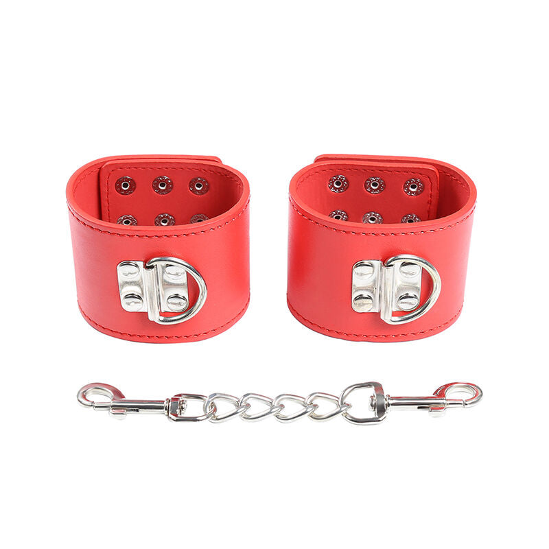 Menottes de poignets en cuir rouge a rivets et boucle metallique reliees par une chaine, vue de face, accessoire de contention visuel pour des jeux de domination.