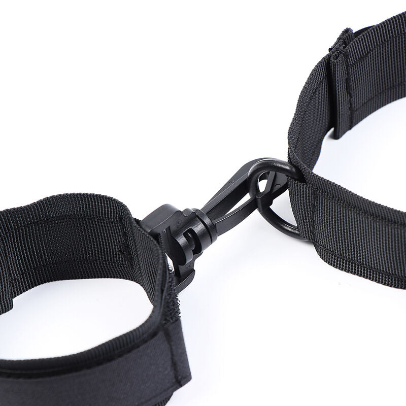 Gros plan sur le mousqueton noir reliant le collier en nylon a une manchette velcro, systeme d'attache du kit de contention souple pour le bondage en couple.