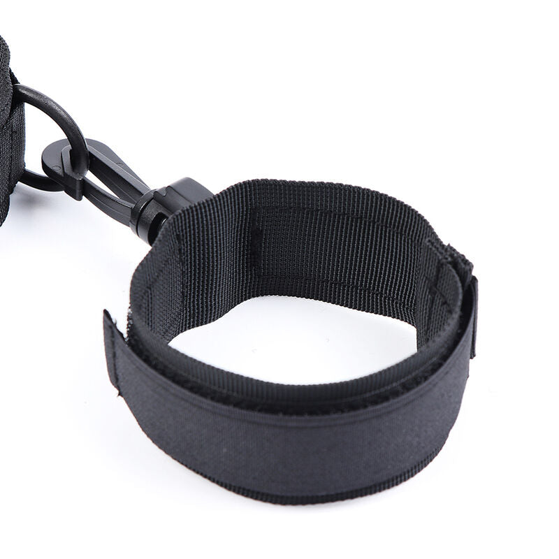 Manchette de poignet en nylon noir a large bande velcro vue rapprochee, anneau d'attache integre, element ajustable et confortable du set de contention pour le bondage.