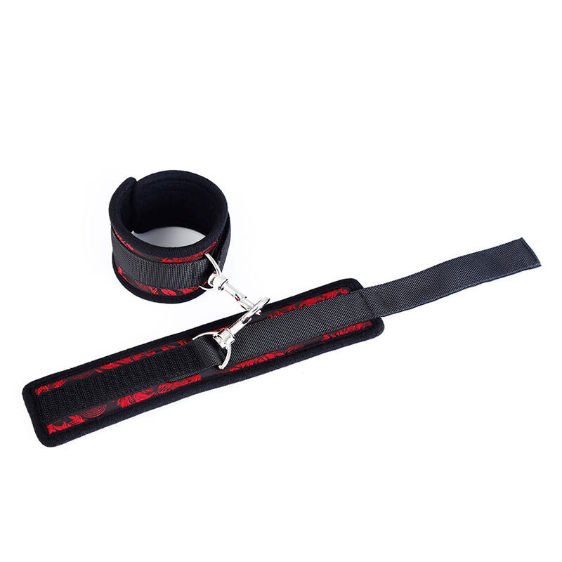 Manchette de poignet neoprene noir borde de rouge avec longue sangle velcro et mousqueton, vue de detail d'un element des menottes Scandal Ohmama.
