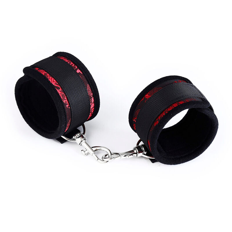Deux bracelets neoprene noir a liseré rouge relies par une fine chaine metallique, vue de face des menottes Ohmama pour jeux de domination doux.