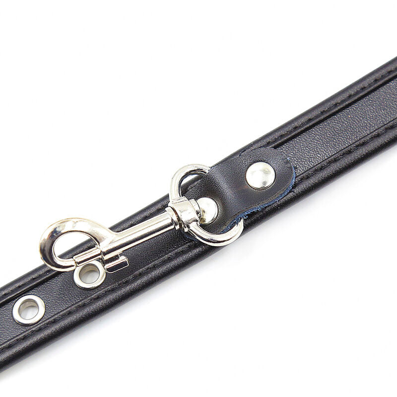 Detail rapproche du mousqueton et de l'anneau metalliques d'une sangle simili cuir noir a oeillets, fixation des manchettes de contention Ohmama.