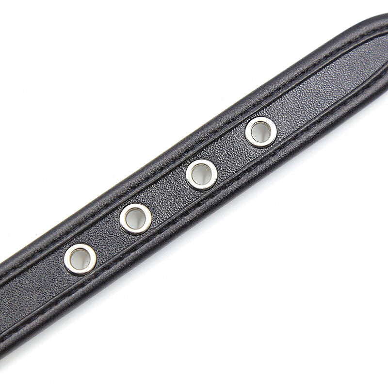 Gros plan sur les oeillets metalliques d'une sangle en effet cuir noir surpiquee, detail du reglage des manchettes d'attache Ohmama pour le bondage.