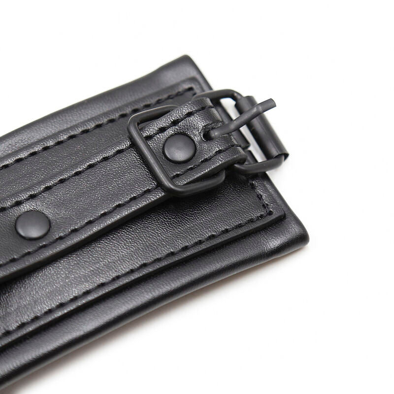 Gros plan sur la boucle et la languette de fermeture d'une manchette simili cuir noir matelassee, detail du reglage des attaches de poignet Ohmama.