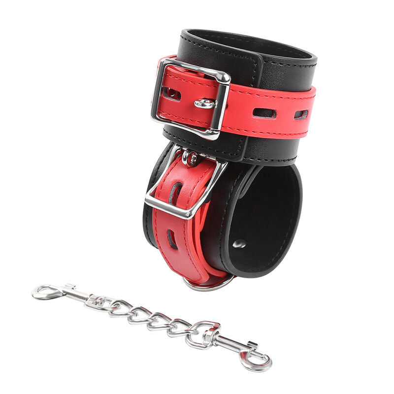 Deux manchettes simili cuir rouge et noir a boucles metalliques empilees, chaine et mousqueton en bas, accessoire de contention colore Ohmama pour le bondage.