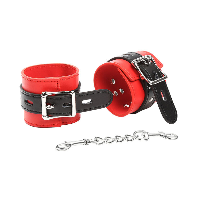 Manchettes simili cuir rouge et noir a boucles metalliques vues de trois quarts, chaine a mousqueton en bas, attaches de poignet bicolores Ohmama pour le bondage.