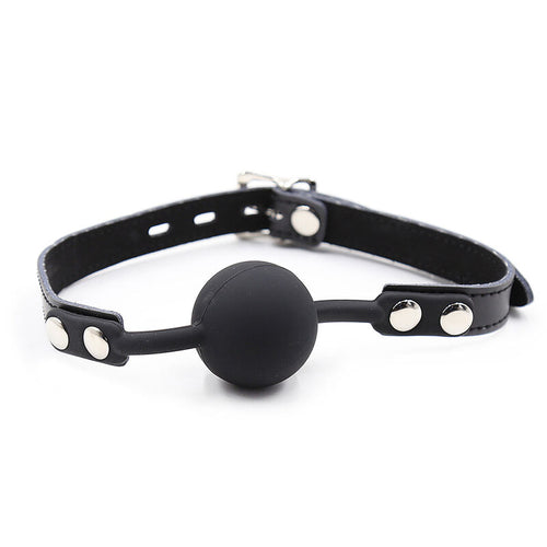 Baillon-boule silicone noir ferme en cercle sur sa lanière a rivets, vue d'ensemble de l'accessoire de domination soft Ohmama a diametre confortable.