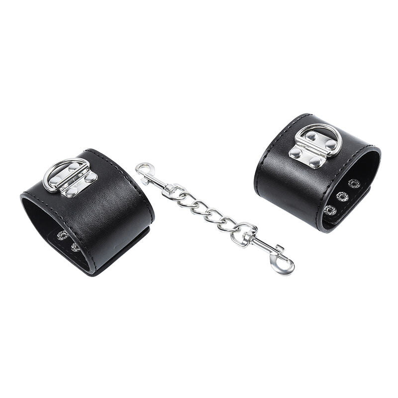 Manchettes de poignets en simili cuir noir enroulees, reliees par une courte chaine a mousqueton, accessoire de contention BDSM Ohmama.