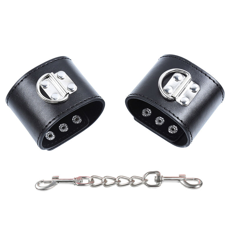 Paire de manchettes en simili cuir noir a fermeture pression et rivets avec chaine de liaison, accessoire de contention BDSM Ohmama, taille unique.