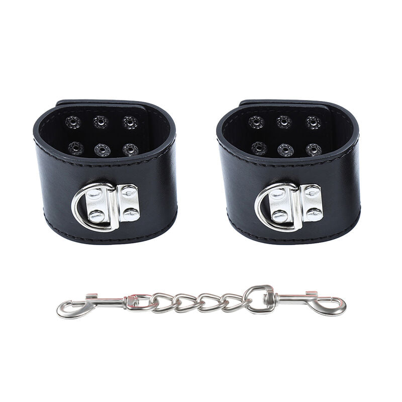 Manchettes de poignets en simili cuir noir vues de dessus, rivets metalliques et chaine a mousqueton, kit de contention BDSM Ohmama.