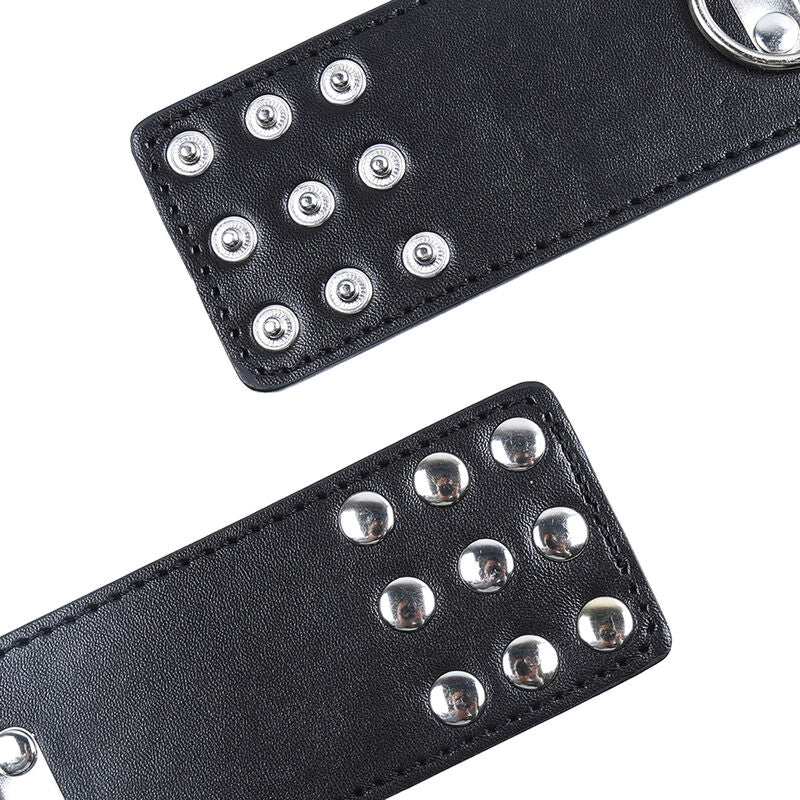 Gros plan en angle de manchettes en simili cuir noir a rivets et fermeture pression, detail de la finition de l'accessoire de contention Ohmama.