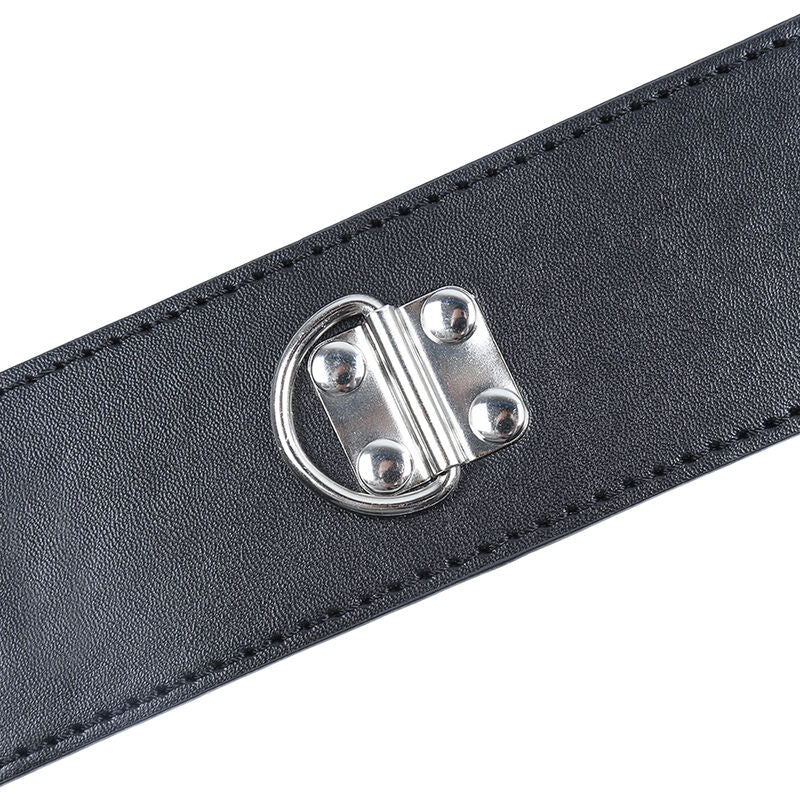 Macro de la fermeture metallique a crochet d'une manchette en simili cuir noir Ohmama, detail de la quincaillerie de l'accessoire de contention BDSM.