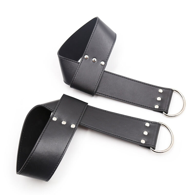Paire de manchettes de suspension en simili cuir noir pliees, anneaux D argentes visibles, accessoire de contention modulable BDSM Ohmama.
