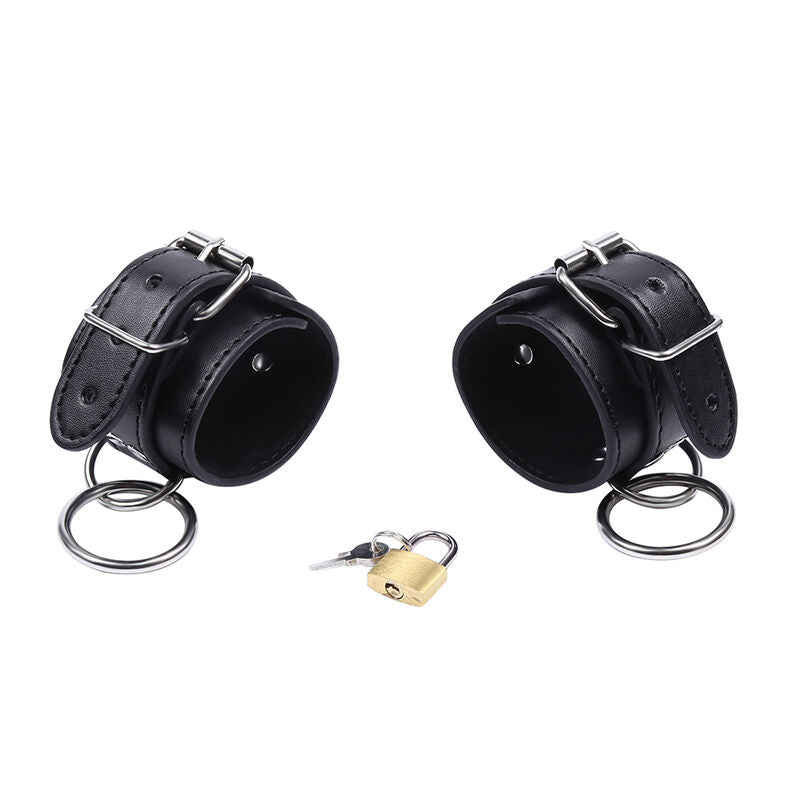 Deux manchettes de poignets en simili cuir noir a boucles et anneaux O, cadenas pose a cote, kit de contention verrouillable BDSM Ohmama.