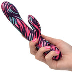 Vibrateur double Ménage à Moi en silicone zébré tenu en main, mettant à l'échelle ses deux branches souples pour la stimulation clitoridienne et interne simultanée.