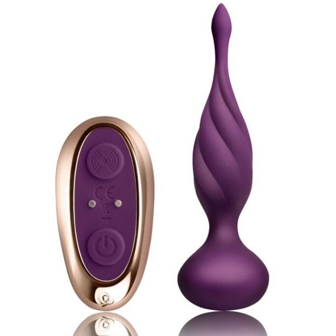 Plug anal vibrant en silicone violet torsadé à pointe effilée, col fin et base bulbeuse, posé près de la télécommande ovale dorée, surfaces lisses non anatomiques.