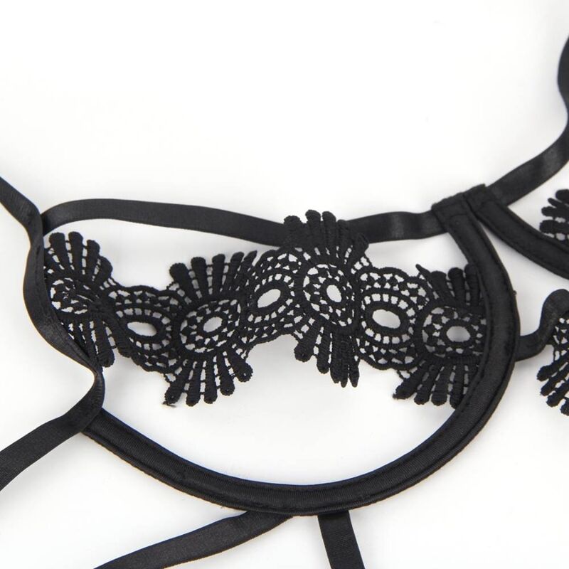Gros plan sur l'applique de dentelle florale du bonnet et les sangles du teddy strappy Subblime, broderie festonnée noire posée à plat sur fond blanc.