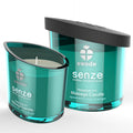 Bougie de massage Swede Senze Tranquillite menthe rose orange, gros plan du verre teal allume a cote de son couvercle, cire naturelle bio aux huiles essentielles.