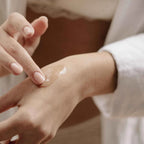 Application du serum Sex au Naturel Bijoux Indiscrets sur le dos de la main, gros plan sur les doigts etalant le soin, demonstration de la texture du serum clitoridien
