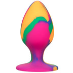 Plug anal Cheeky Large en silicone tie-dye rose, jaune et vert sur base ventouse, vue de face du corps lisse et bombé de 9 cm pour le jeu mains libres.