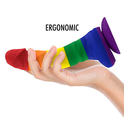 Gode Corey Pride aux couleurs arc-en-ciel a la forme penienne avec testicules tenu dans une main paume ouverte, base ventouse, ergonomie du modele Mythology