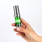 Flacon airless vert Liquid Vibrator Fresh tenu en main, gel stimulant Secret Play effet froid menthe, gros plan presentant le format compact de l'intensificateur unisexe.