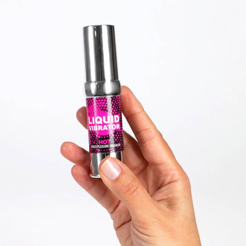 Flacon airless rose Liquid Vibrator Hot tenu dans une main, gel stimulant Secret Play effet chaud fraise creme, gros plan presentant le format compact du produit.