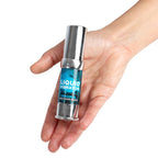 Flacon Liquid Vibrator Original tenu en main vue inclinee, gel stimulant unisexe effet vibrant, pompe argentee et design bleu Secret Play.