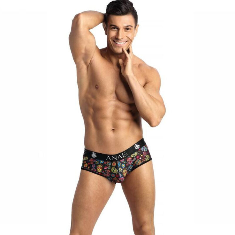 Homme muscle torse nu main au menton portant le slip Mexico a tetes de mort colorees, ceinture Anais, lycra moulant, lingerie masculine festive.