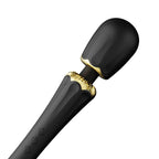 Gros plan incliné de la tête bombée du wand Kyro noir et de son col doré, surface lisse brillante du silicone, vibrations ciblées, aucun détail anatomique.