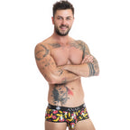 Boxer bananes et bouches porte de face sur torse nu tatoue, lycra doux, ceinture Anais, coupe sportive ajustee, imprime coquin colore, bras croises.