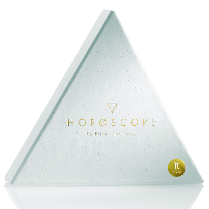 Etui triangulaire blanc Horoscope Bijoux Indiscrets avec badge du signe Gemeaux, packaging du coffret horoscope bien-etre sur fond blanc