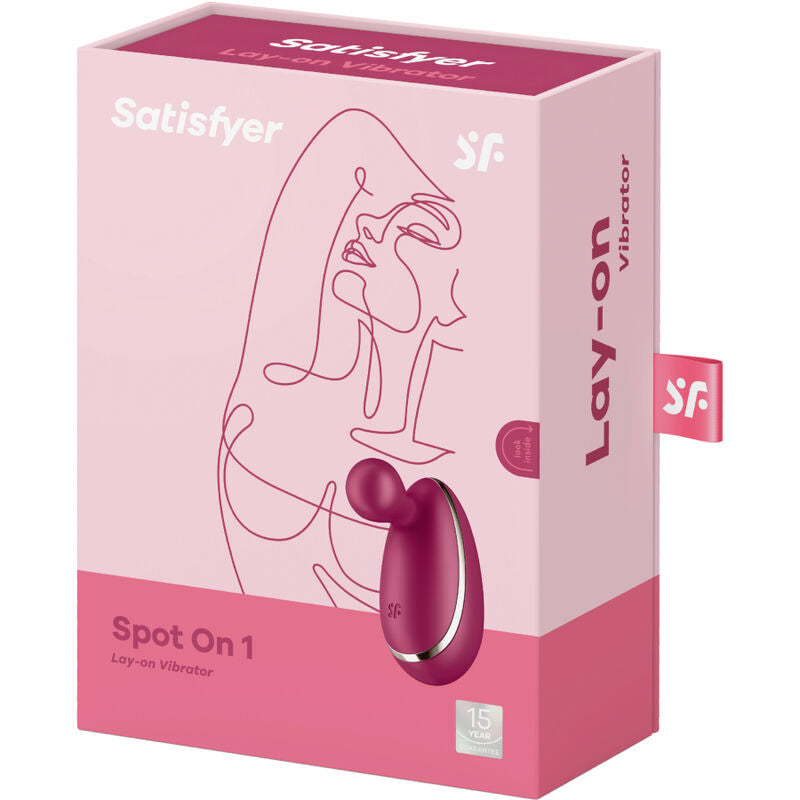 Boite rose Satisfyer Spot On 1 Lay-on Vibrator avec dessin stylise de visage et illustration du stimulateur bordeaux, pointe flexible en silicone, etanche rechargeable