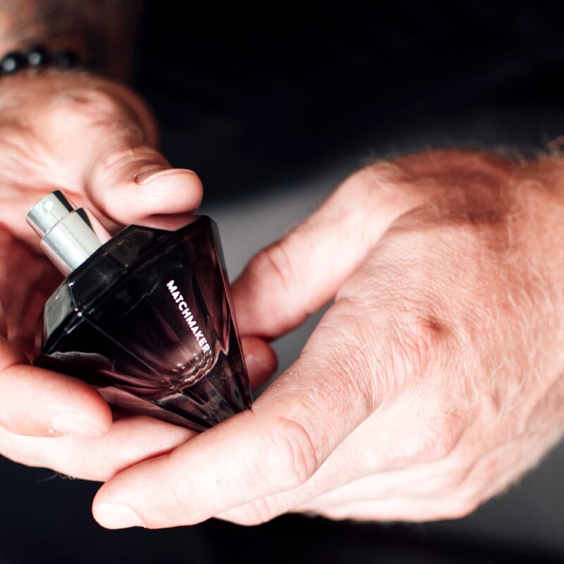 Flacon diamant noir du parfum aux phéromones Matchmaker Black Diamond tenu dans deux mains masculines, eau de parfum facette a bouchon cristal, gros plan lifestyle Eye Of Love.