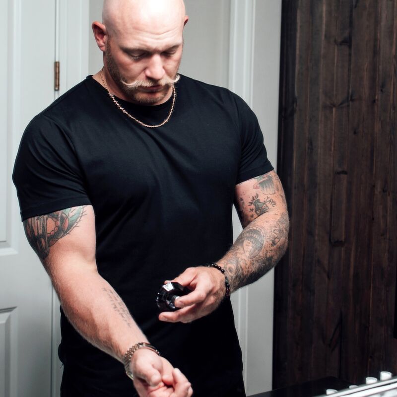Homme en t-shirt noir tenant le flacon diamant noir du parfum aux phéromones Matchmaker Black Diamond, scene masculine assuree de la gamme Attract Her Eye Of Love.