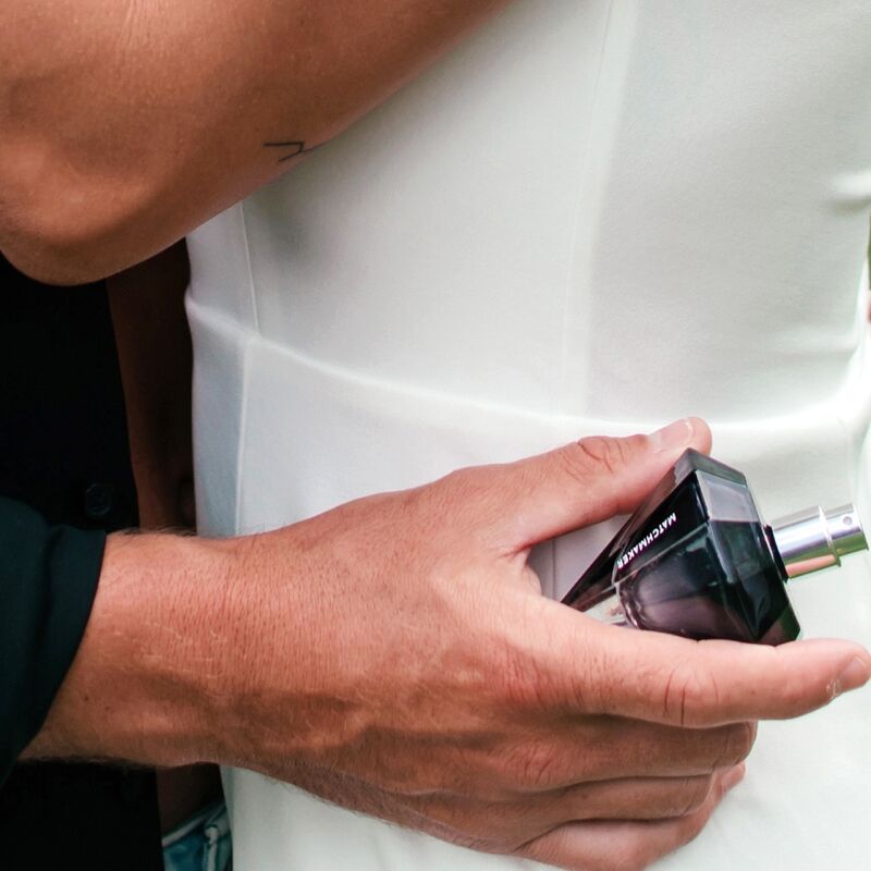 Homme en t-shirt blanc vaporisant le flacon diamant noir du parfum aux phéromones Matchmaker Black Diamond, eau de parfum facette en main, scene lifestyle Eye Of Love.