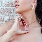 Femme epaules denudees appliquant le roll-on Matchmaker Red Diamond sur le cou, mise en situation du parfum aux pheromones unisexe 10 ml Eye Of Love.