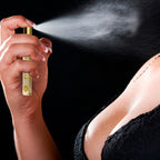 Femme en lingerie noire vaporisant un parfum vers le decollete, mise en situation du parfum aux pheromones pour femme After Dark Eye Of Love.