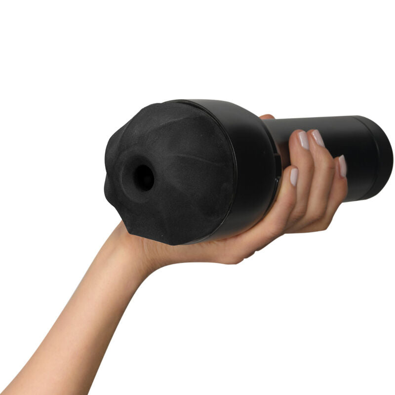 Masturbateur fume Kiiroo tenu en main, ouverture lisse noire non realiste et coque souple translucide ; jouet masculin compact compatible module d'aspiration a depression.