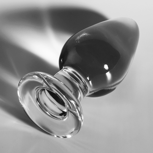 Gros plan en biais du plug anal conique en verre borosilicate transparent, corps bombe brillant et base annelee, surface lisse adaptable a la temperature.