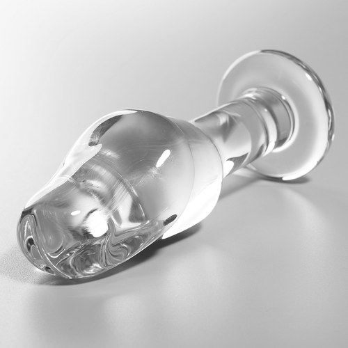 Gros plan en biais du plug anal verre borosilicate transparent, tete galbee texturee et base annelee brillante, surface lisse adaptable chaud et froid Nebula Series.